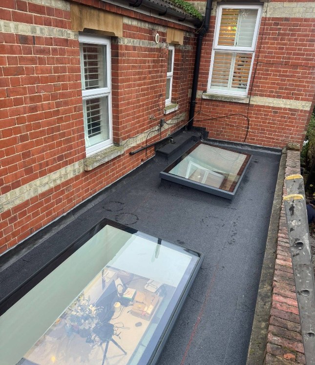New flat roof fitted with two large rooflights on a Surrey extension