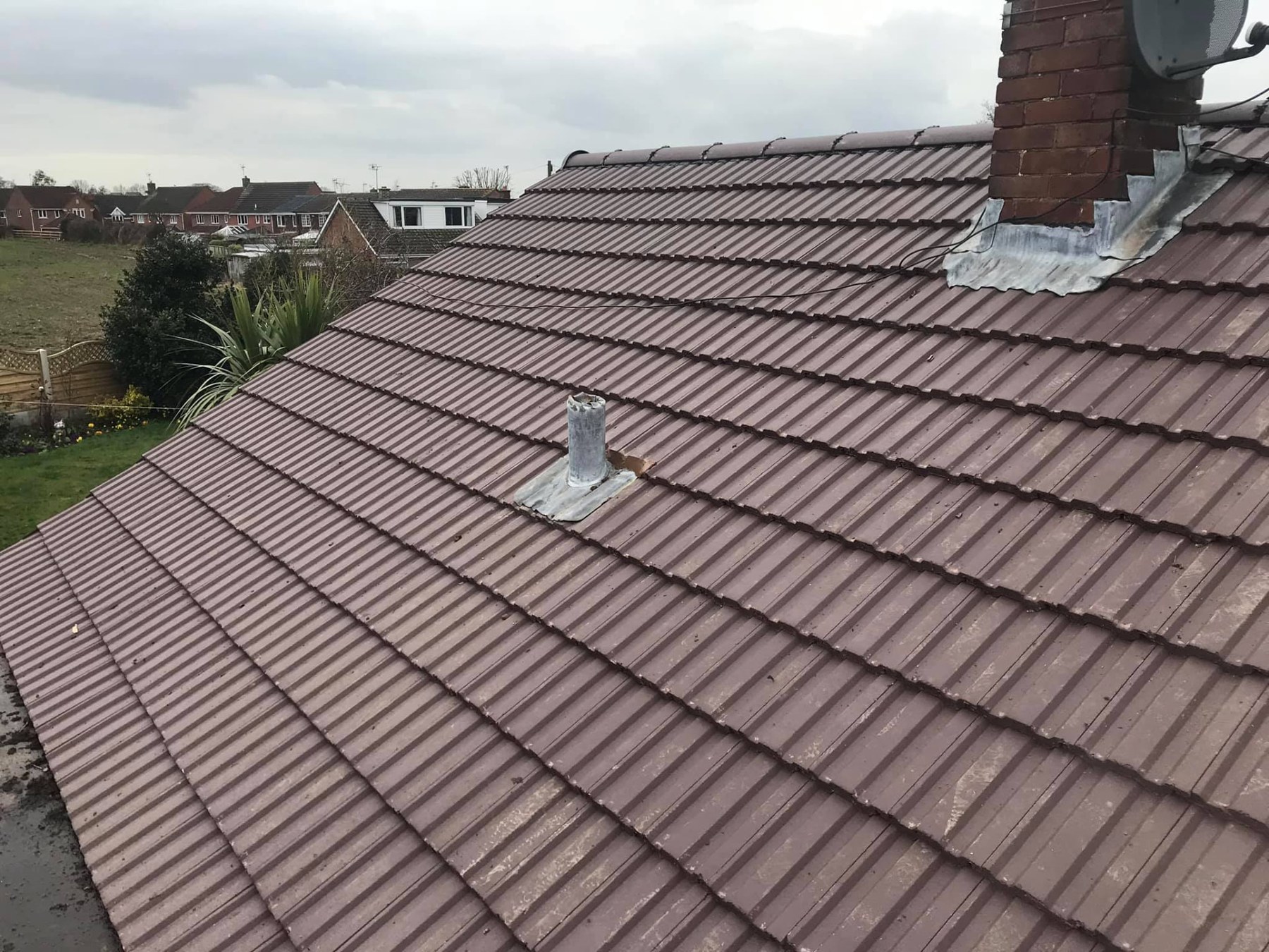 New lead flashing dressed around a chimney stack on a tiled roof
