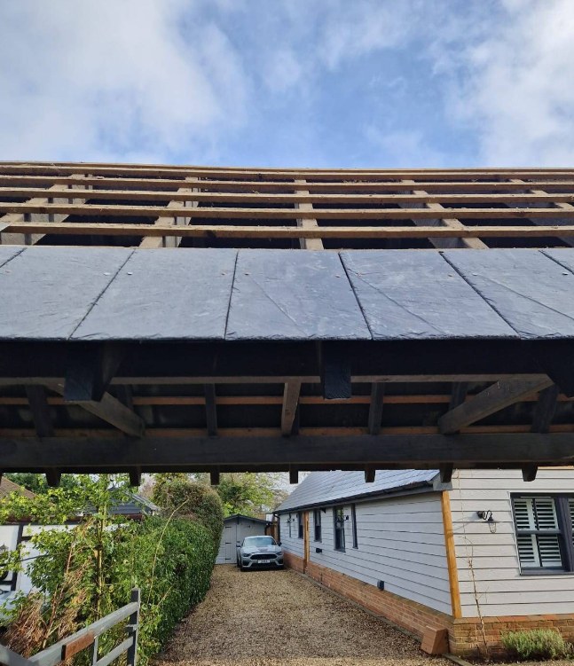Underside of an oak framed porch roof looking towards the house