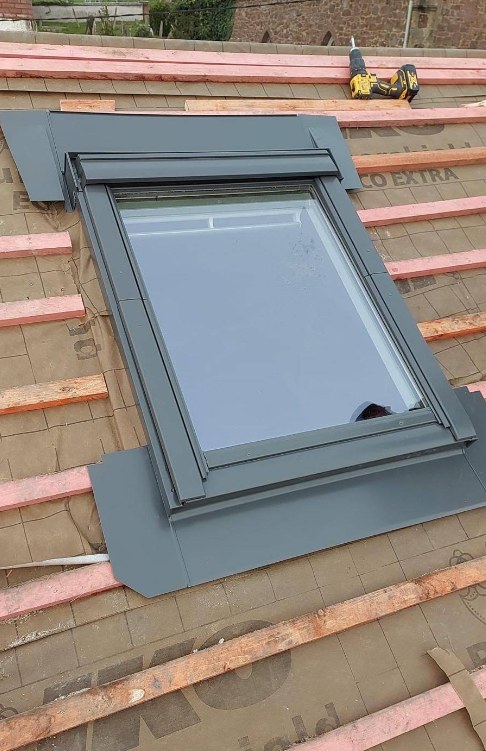 Black roof window integrated into a battened roof before tiling