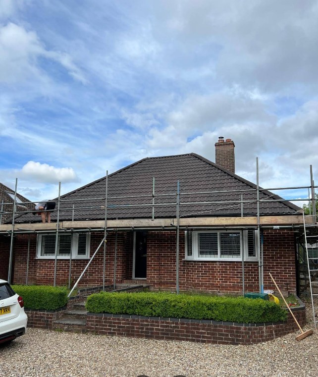 Red brick bungalow fully scaffolded during a re-roof in Berkshire