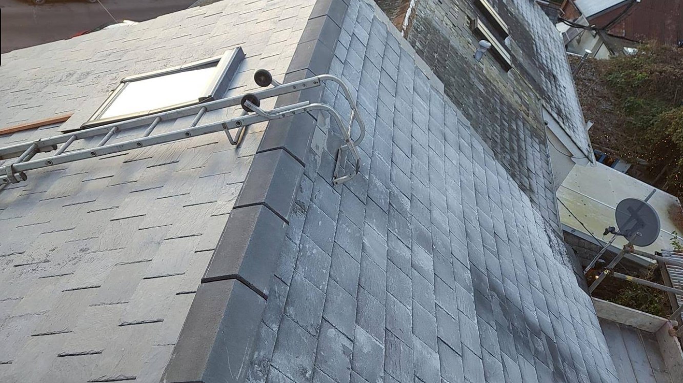 Slate roof with roof window and roof ladder in place mid-installation